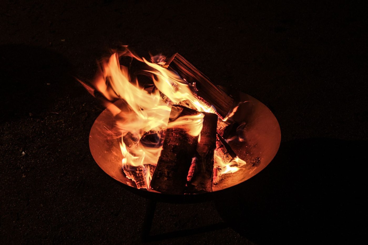 A close-up view of a campfire, showcasing vibrant flames against a dark night backdrop.